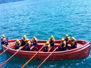 Cadets rowing in an open-type lifeboat.