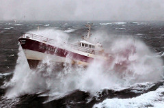 Fishing boat dancing on the rough sea.