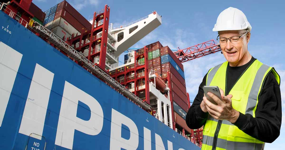A man using his mobile phone near a huge container vessel.