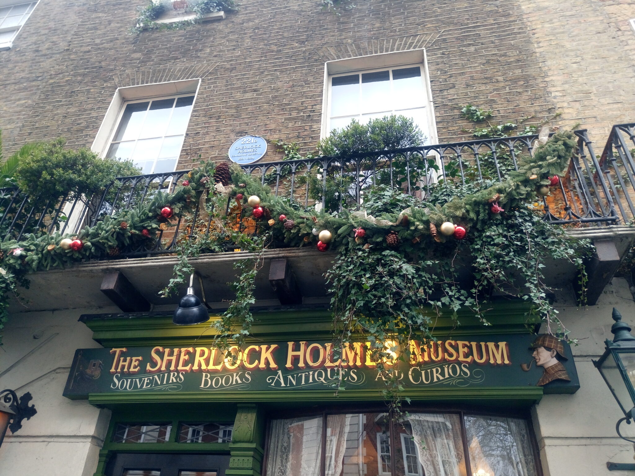 The facade of the Sherlock Holmes Museum filled with vines and Christmas decors.