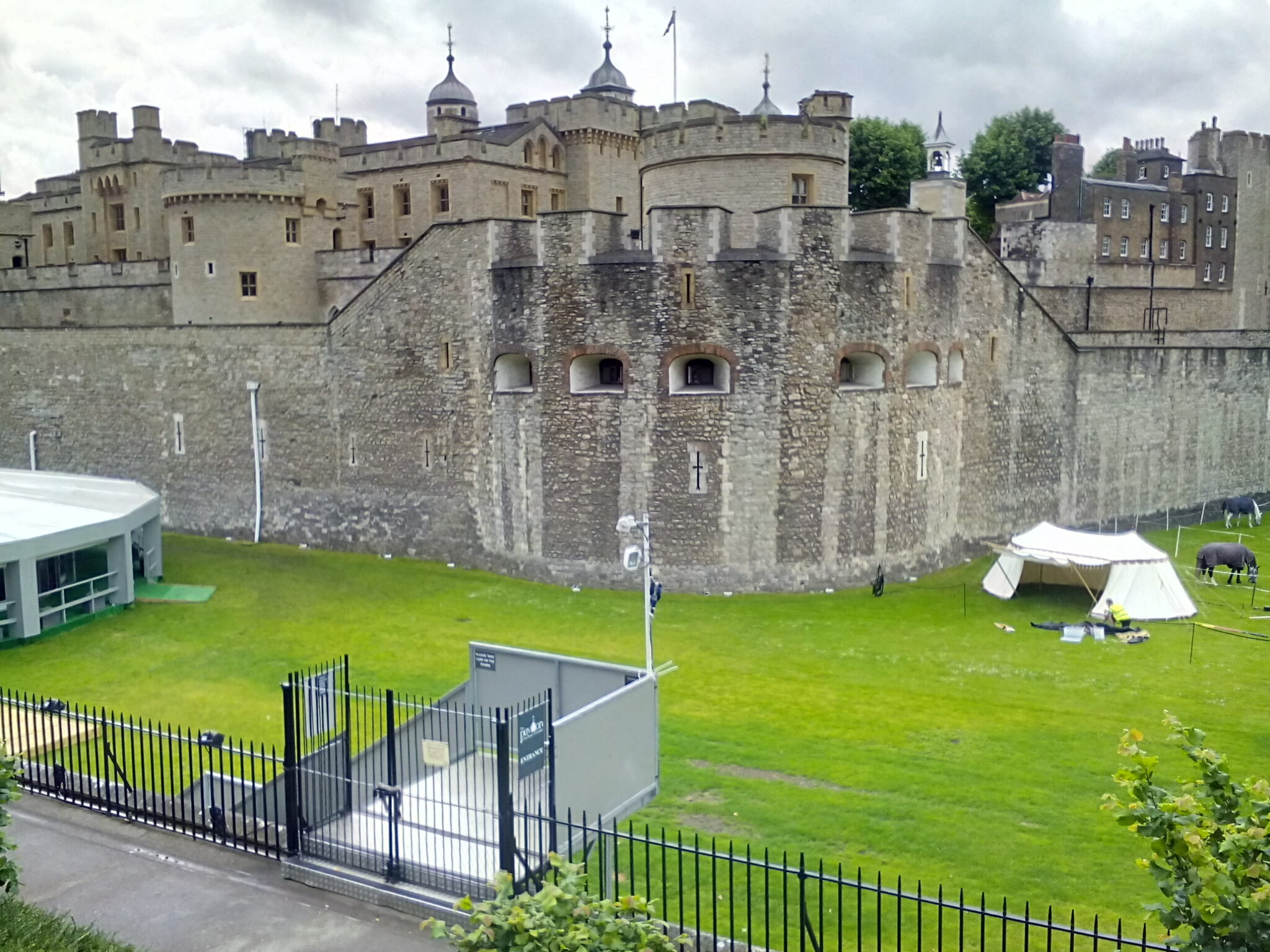 An iconic view of the historic Tower of London, surrounded by a moat, with its medieval architecture and dramatic presence.