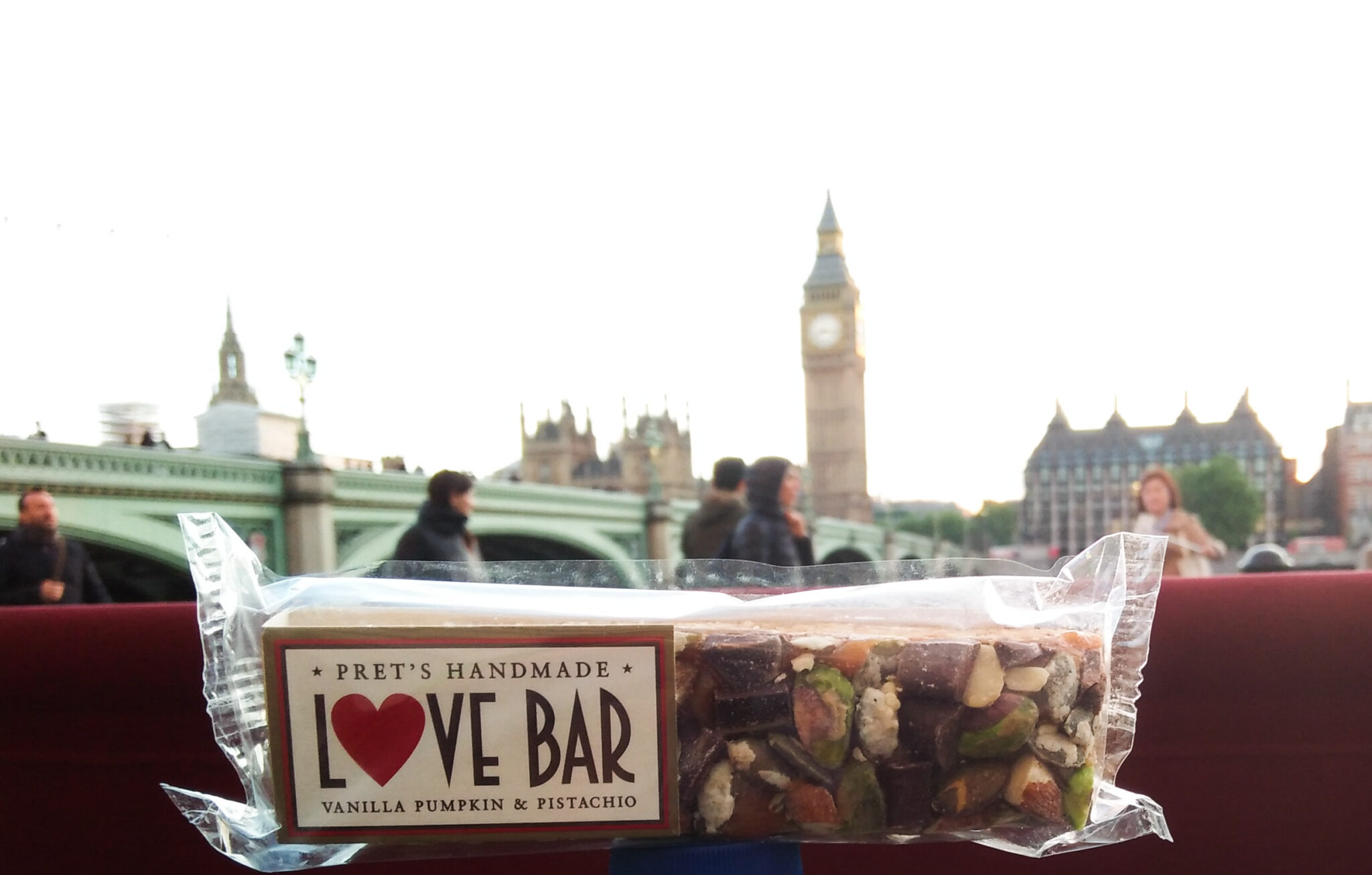 Sitting in a restaurant with a tasty treat called Love Bar while savoring the view of the London Bridge and the Big Ben at a distance.