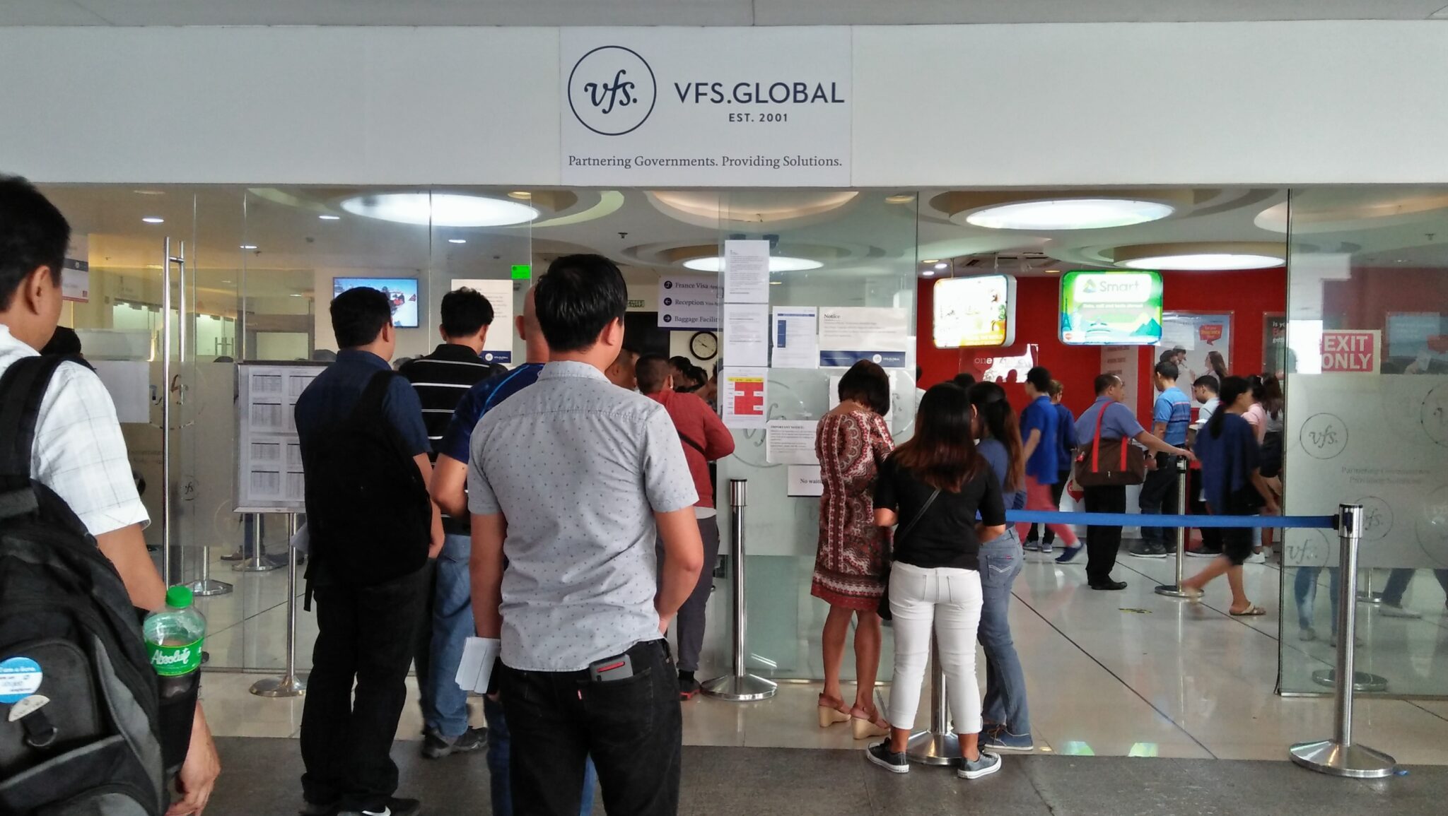 Applicants falling in line near the entrance of VFS Global.