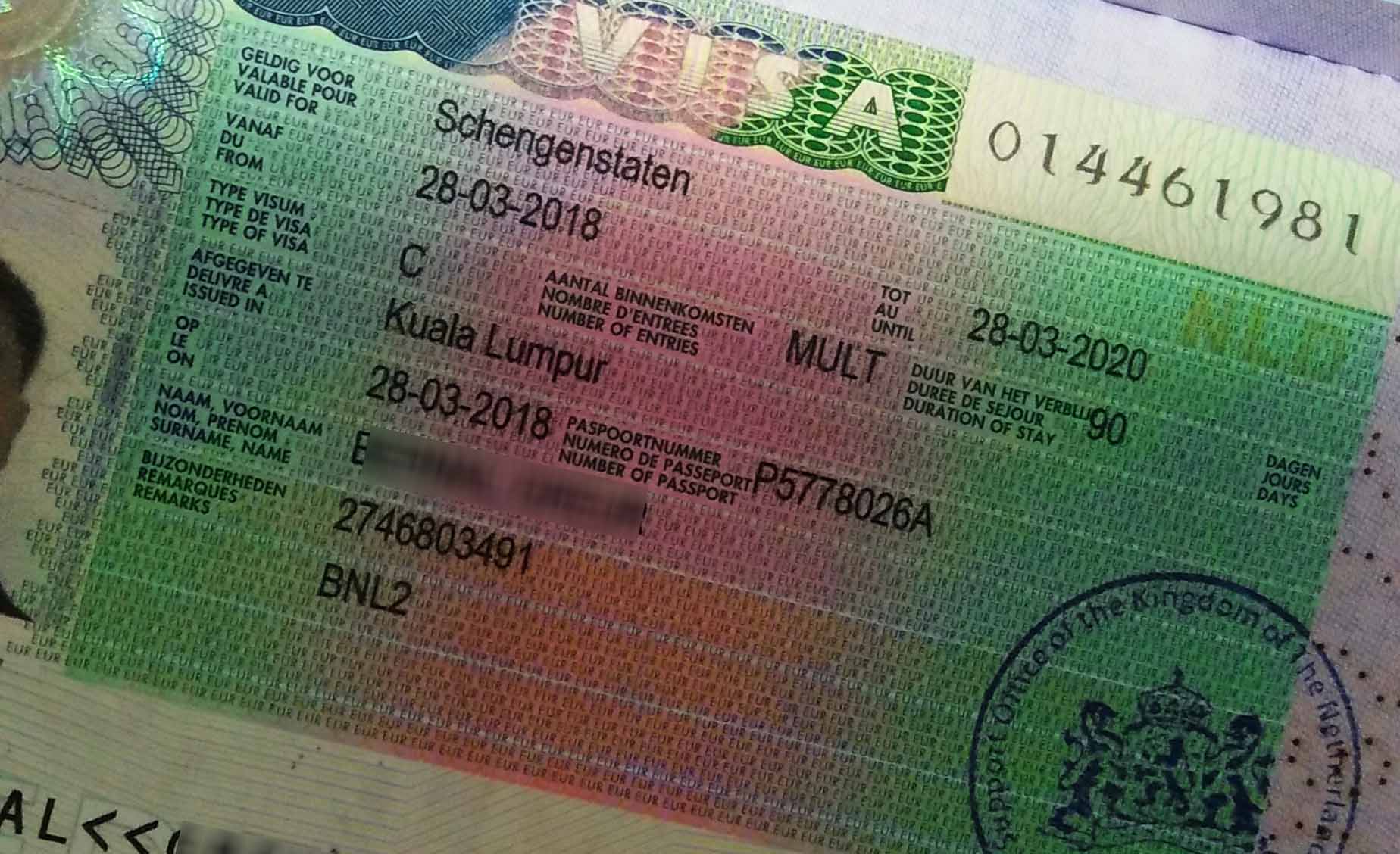 A Schengen Visa attached to a passport.