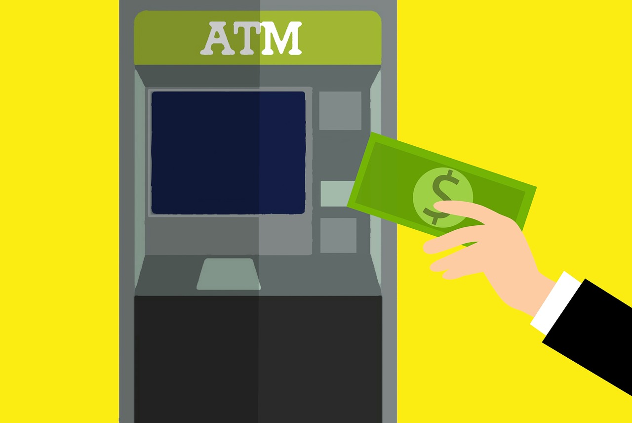 A hand taking out money from an ATM Machine.