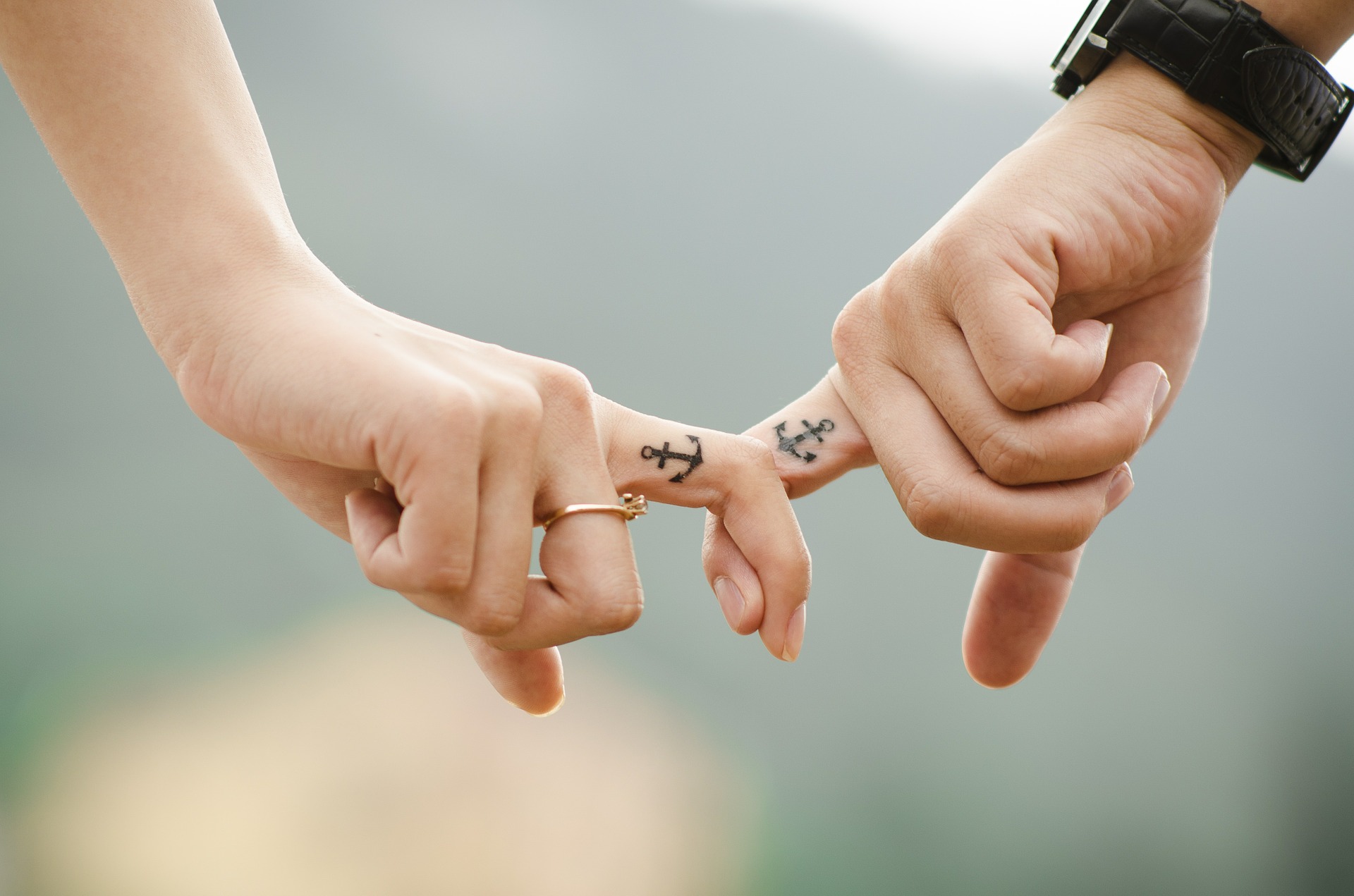 Seaman and girlfriend holding hands with anchor tattoos on their fingers