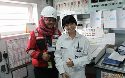 Hiroka taking a photo with a female inspector in the Cargo Control Room.