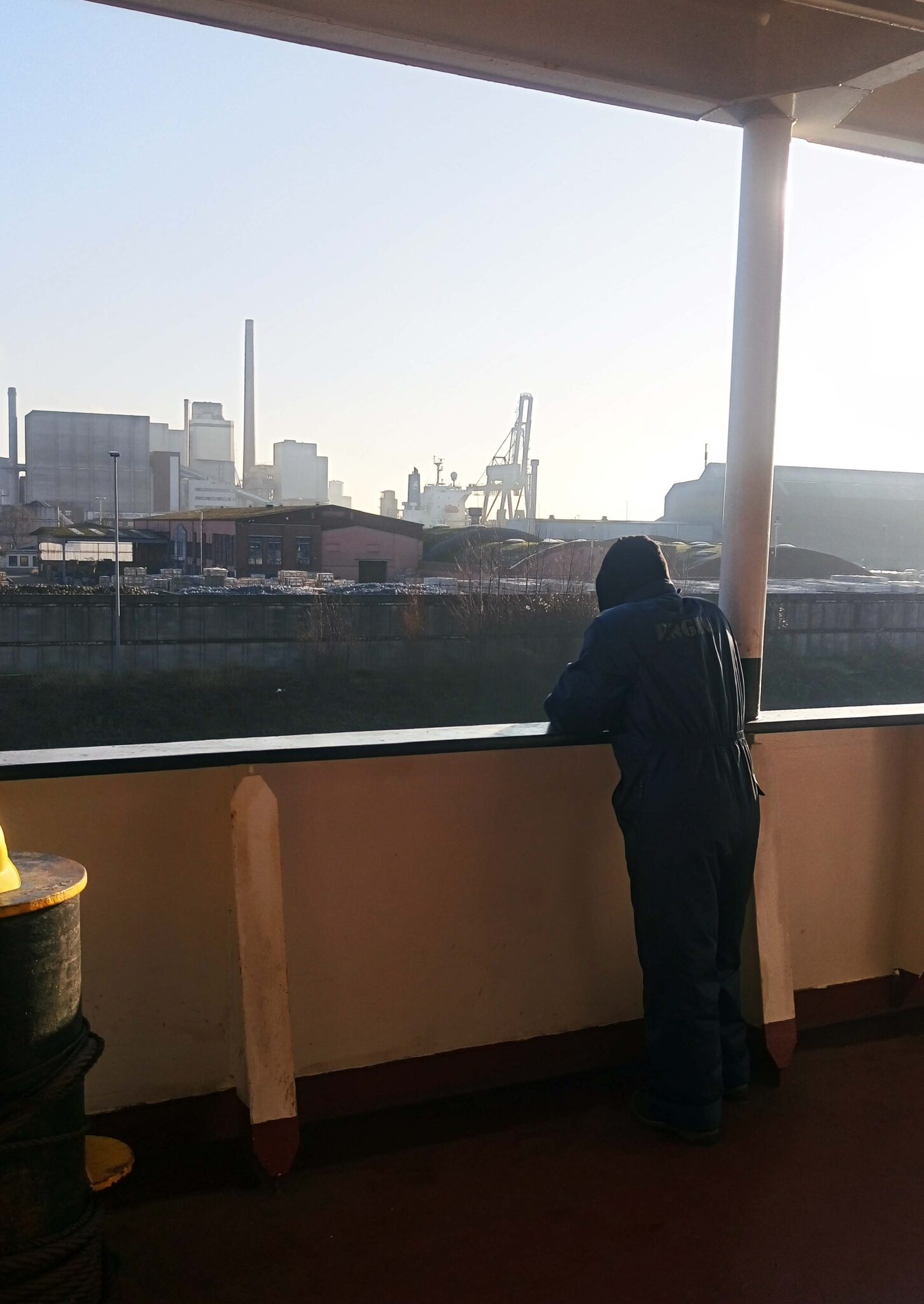 Seafarer in the ship's side watching the waters.