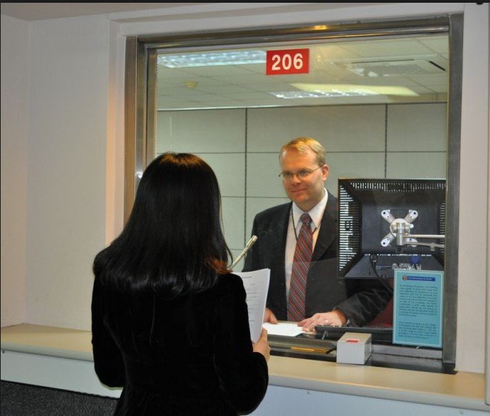 An applicant in front of a consul during a US visa interview.