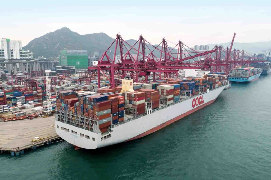 An OOCL container vessel docked in a huge terminal performing cargo operation.