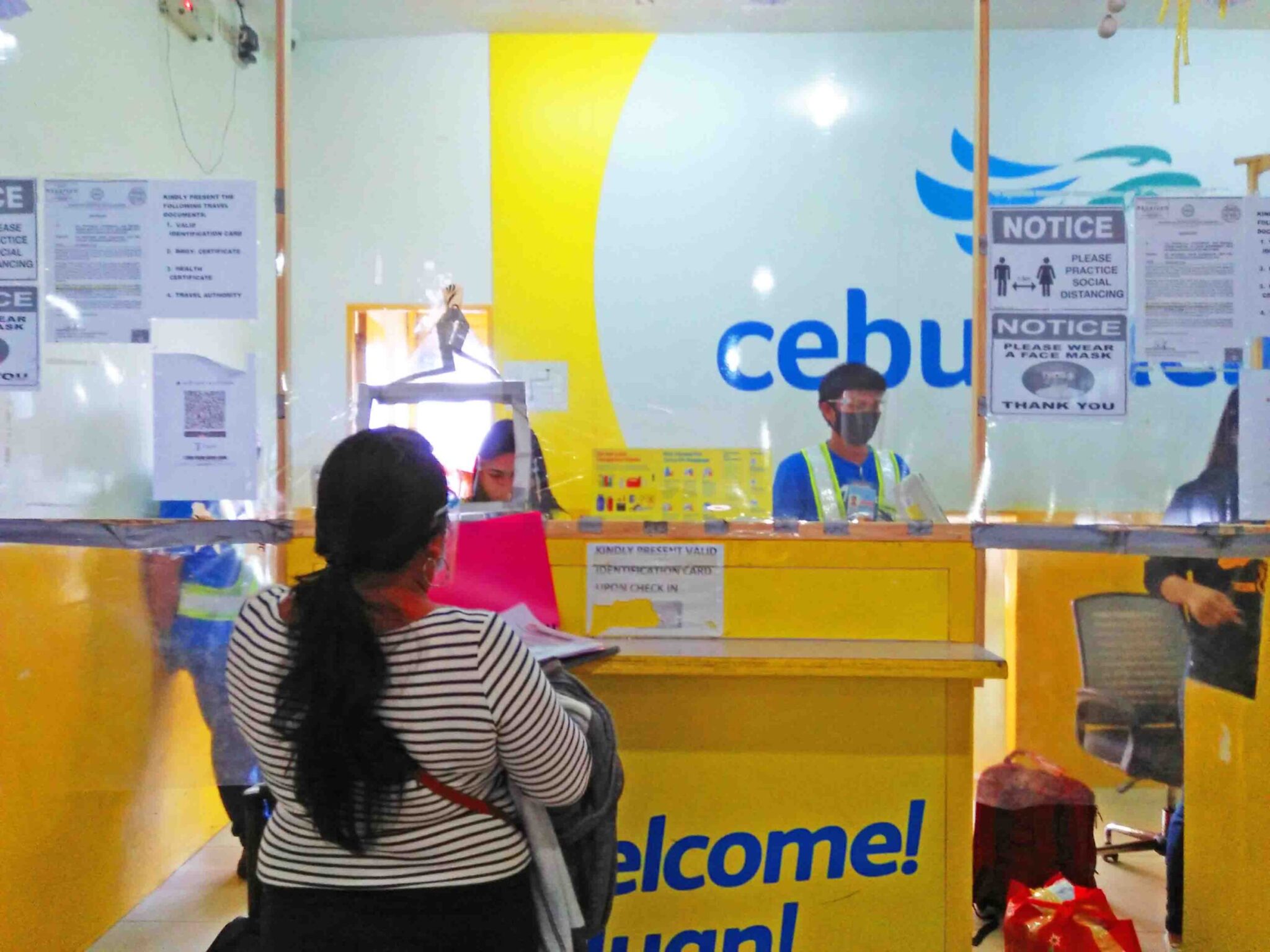 Check in counter at the Cebu Pacific Airline where passengers and  crew all wear PPE.