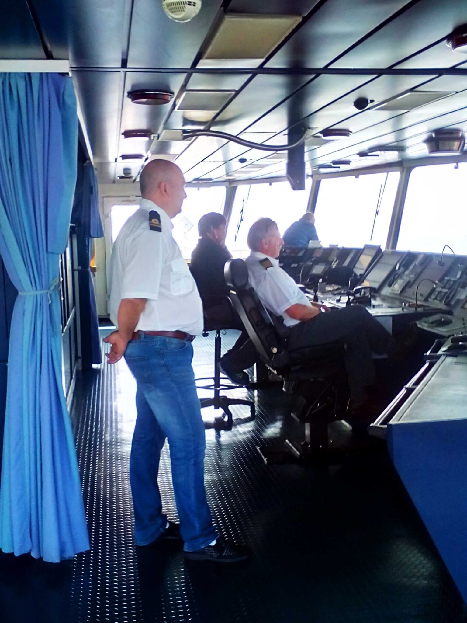 The Second Mate, Captain, Pilot, and helmsman on the bridge during pilotage operation.