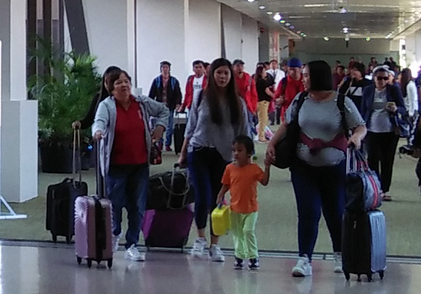 OFWs and seafarers in the airport just finished deplaning and are now headed to the exit.
