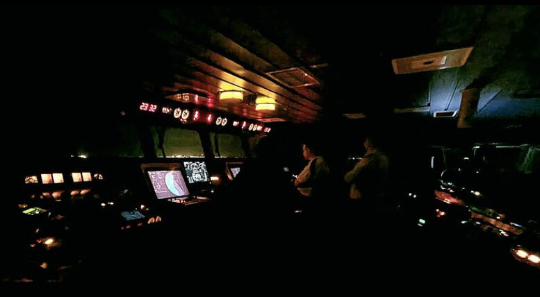 The ship channeling during night time where various controls and indicators are lit up.