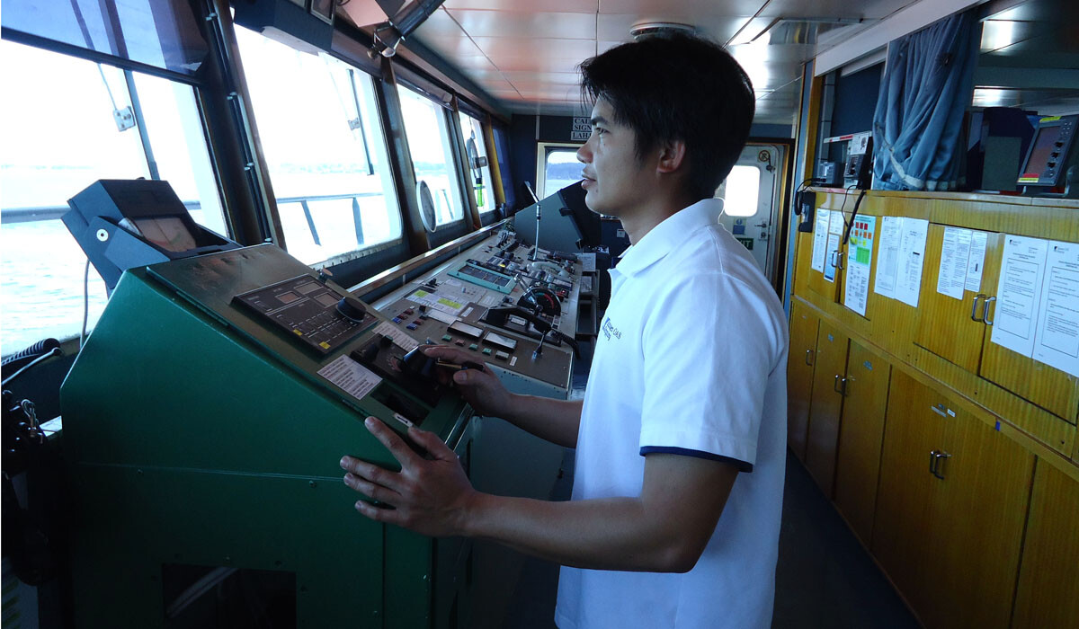 Helmsman Behind the Wheel of a Ship Using a Joystick for Steering