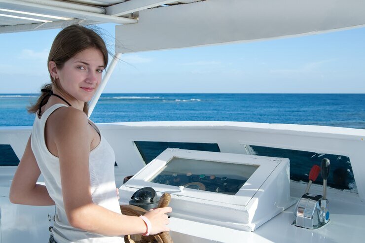 Girl on the steering wheel as the helmsman of a yacht.