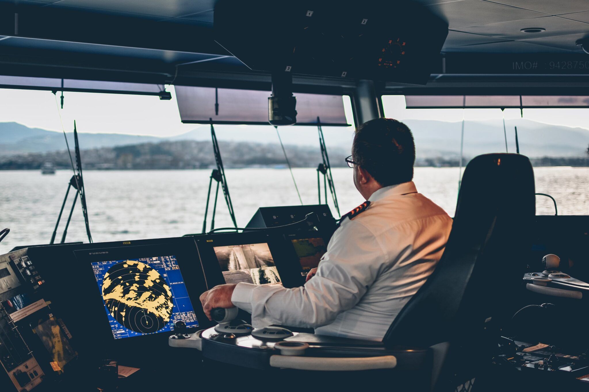 A Master Mariner in his Chair controlling the ship using bridge equipment, machinery controls, and monitors.