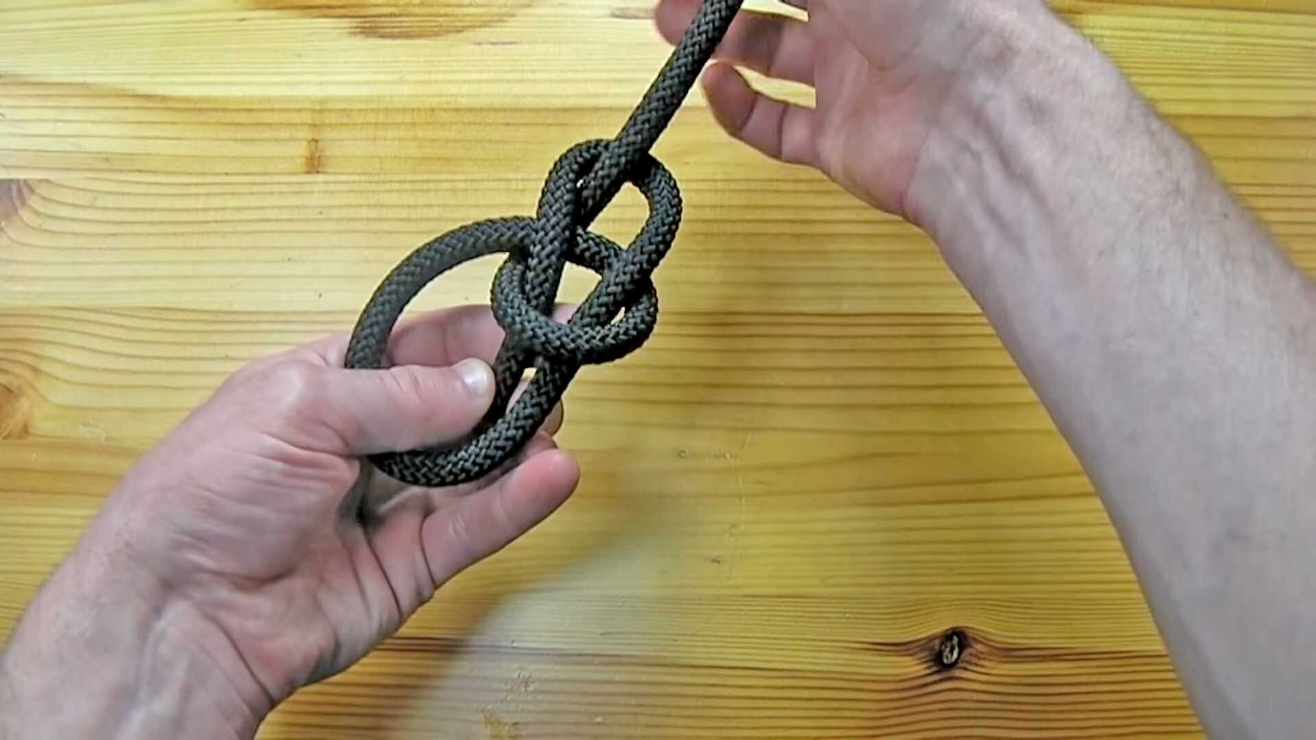 Tying a Bowline Knot using a black rope.