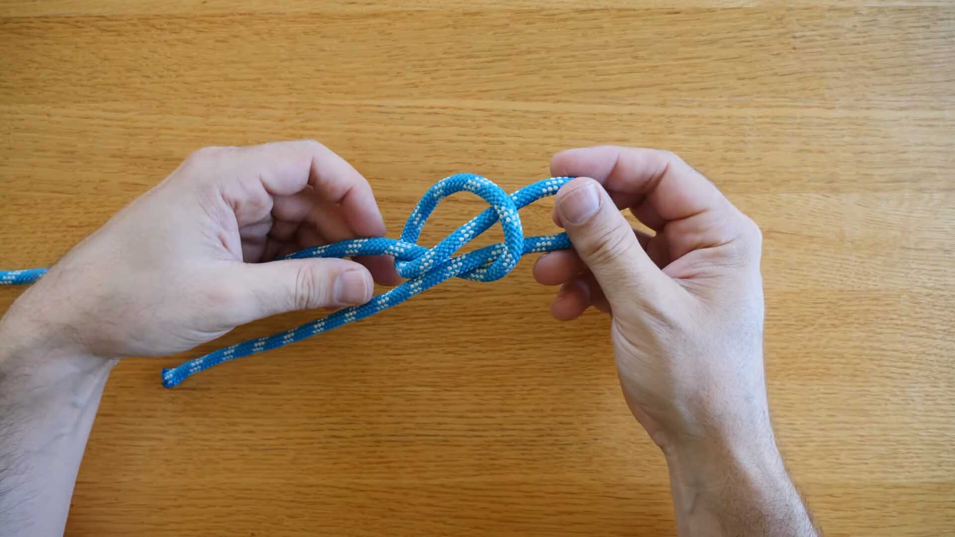 Demonstration on tying a slip knot using a blue rope.