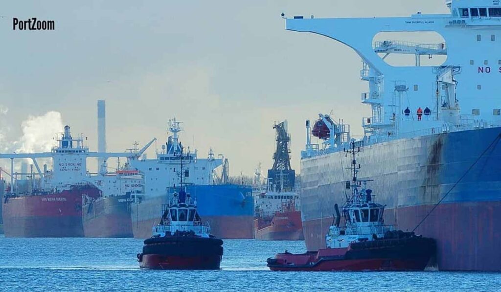 Tugboats assisting a tanker vessel berth alongside a terminal.
