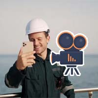 A seaman using his cellphone for taking pictures and videos.