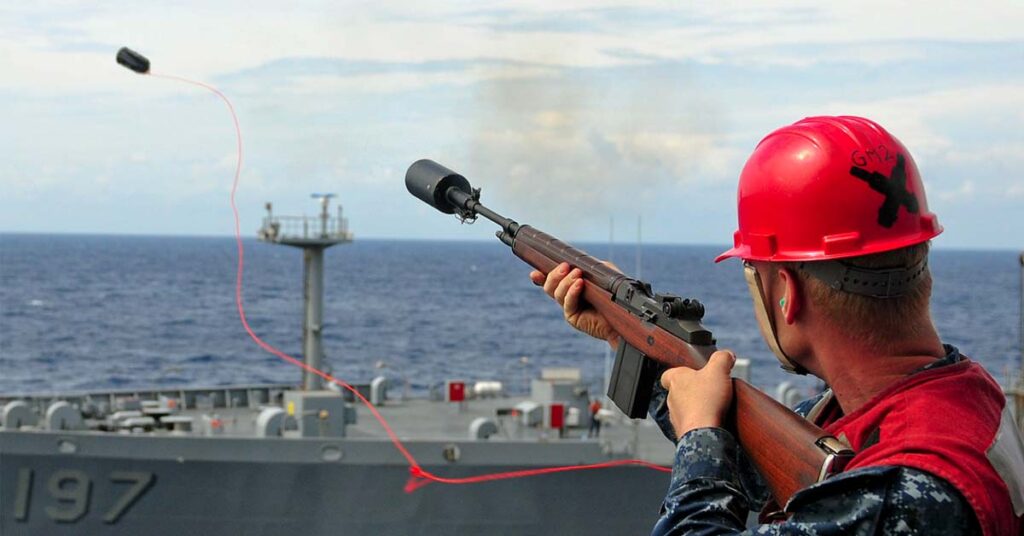 A crew using a line-throwing gun where the projectile is attached to a line and ejected into the air .