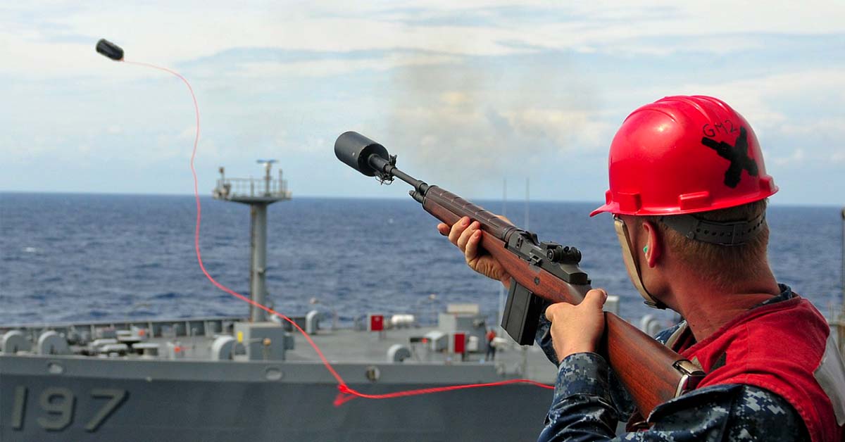 A crew using a line-throwing gun where the projectile is attached to a line and ejected into the air.