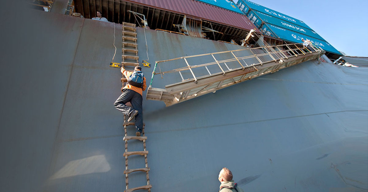 A crew climbing the combination ladder while a responsible person waits on deck.