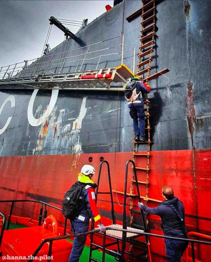 A Pilot disembarking from a ship using a combination ladder- accommodation and pilot ladders rigged together.