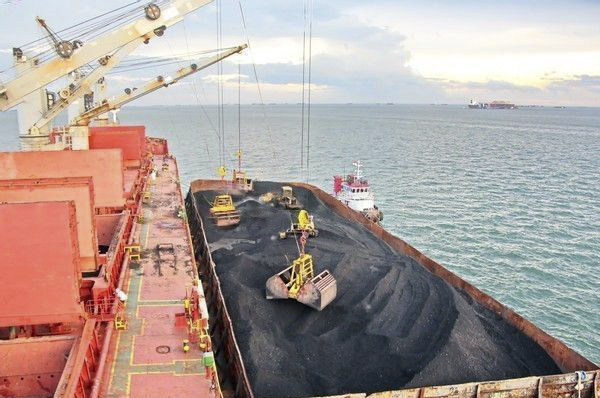 Geared bulk carrier Loading using her own crane while being in an STS operation with a barge..