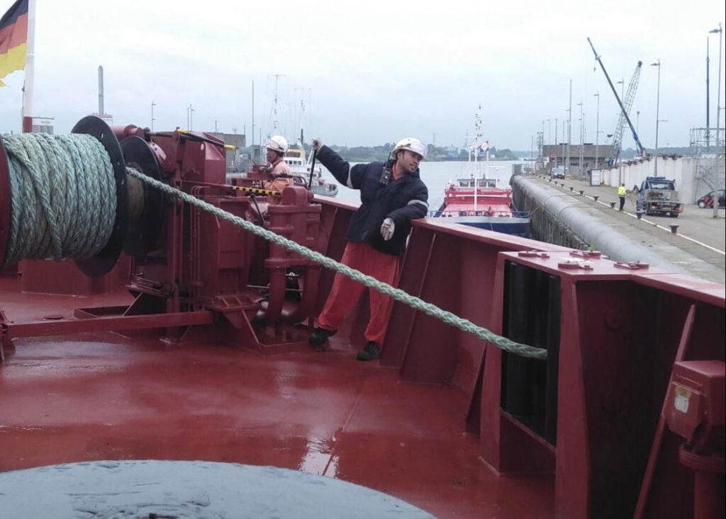 A crew driving the mooring winch as the ship fasts into the lock.