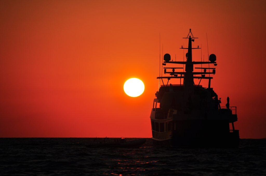 A vessel sailing towards the setting sun.