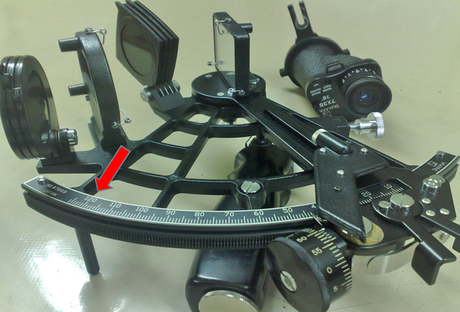 A sextant resting on the table showing its calibration of up to 126 degrees.