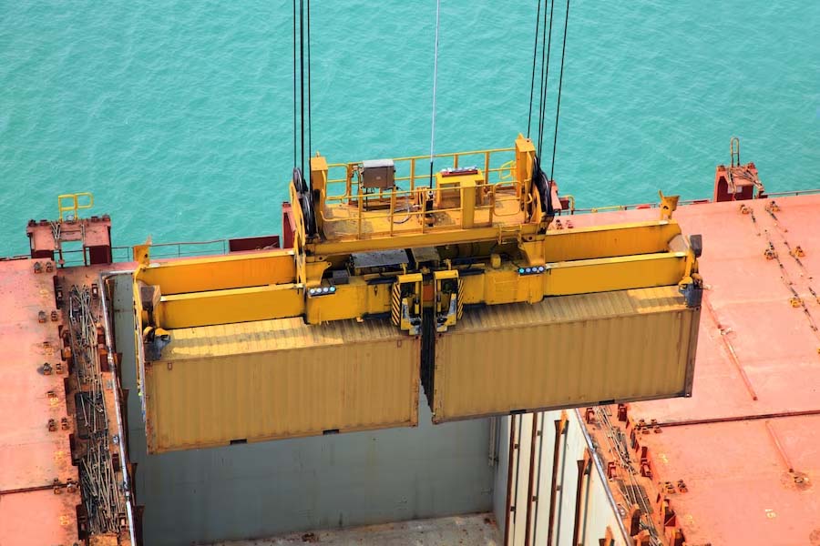 Containers loaded in the cargo hold of a vessel using gantry cranes.