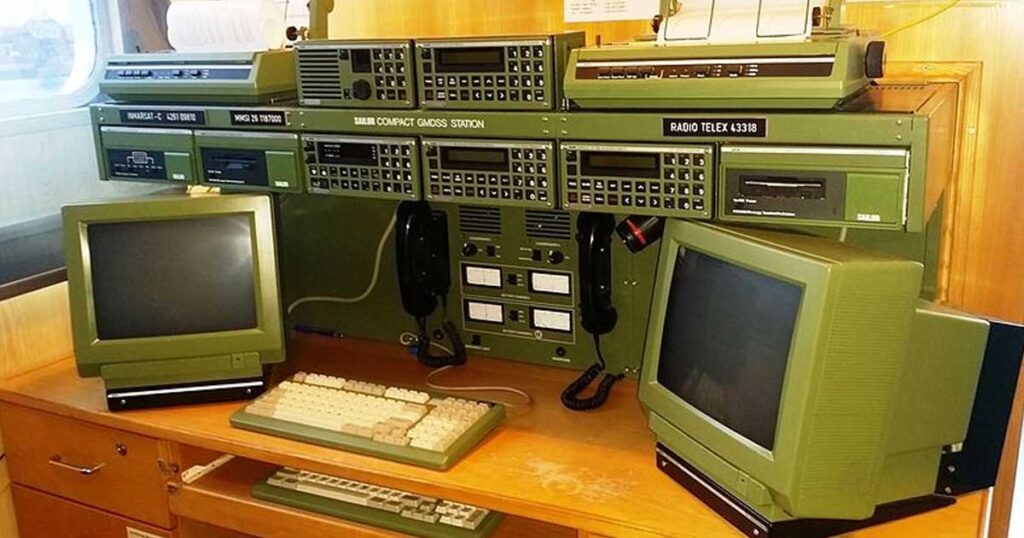 A GMDSS Console consisting of a radio telex, Inmarsat C, printers, two telephone handsets, two monitors, and two keyboards.