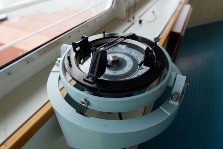 A gyro compass with its pelorus installed on its top.