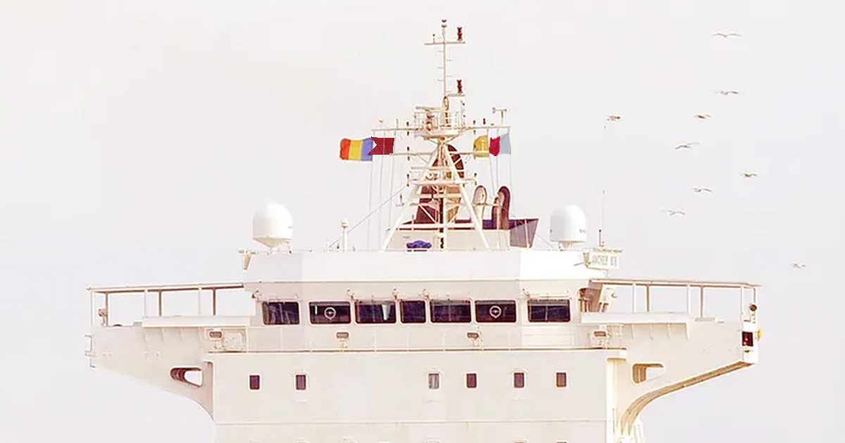 Various ICS flags raised on the ship's bridge mast.
